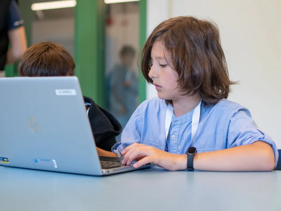 Mellanstadieelev skriver på sin skoldator 